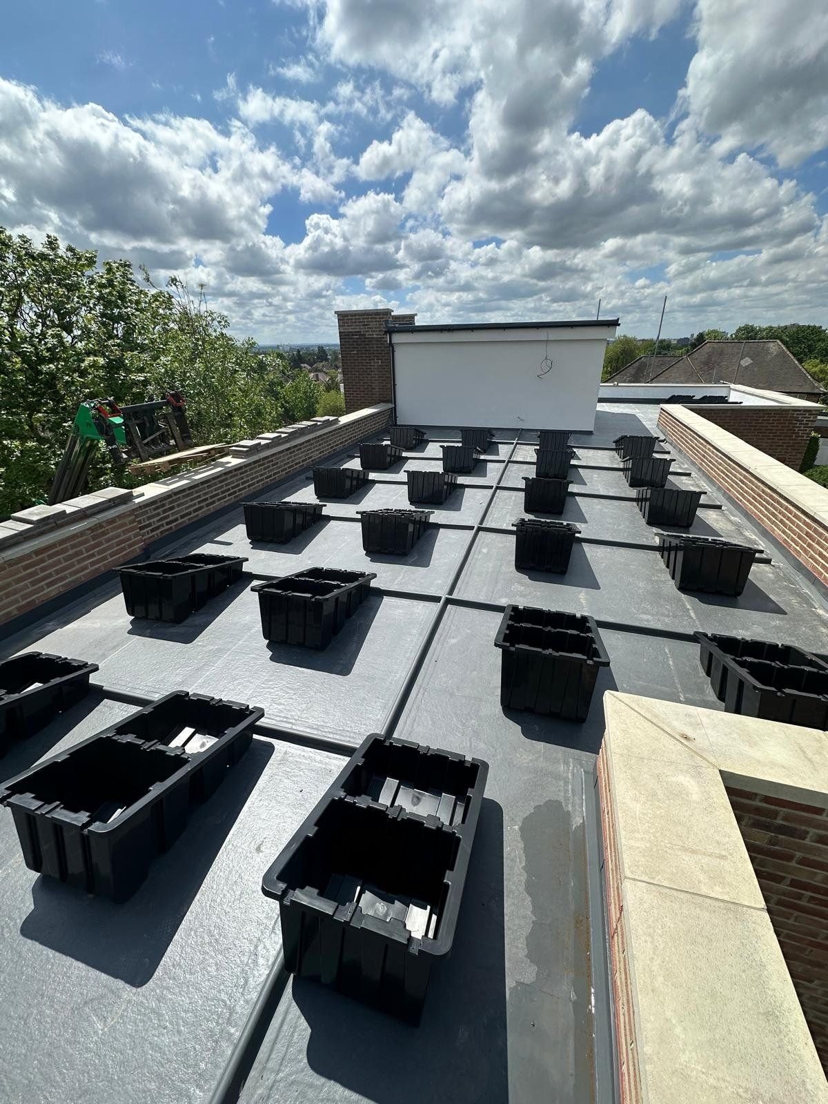 Fast Tub units laid out across a flat roof, positioned around chimneys and parapet walls before ballasting